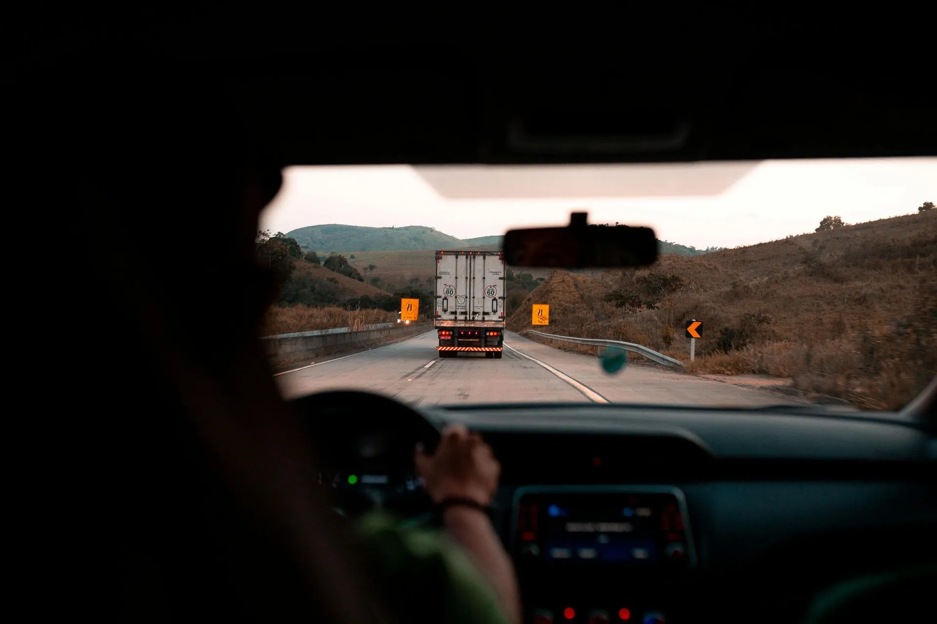 Caminhão em rodovia visto de dentro de um veículo